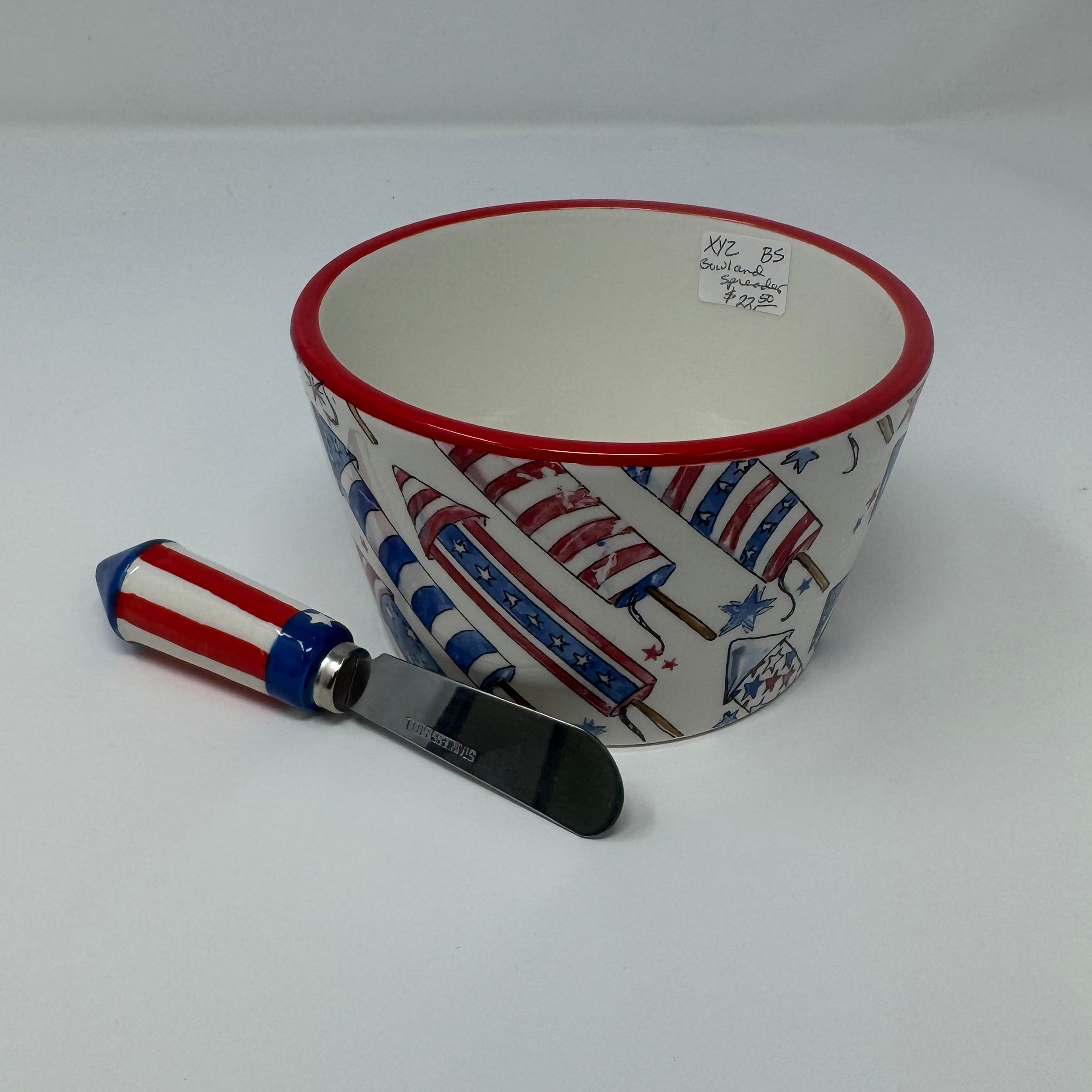 Cup with red, white, and blue design and a matching spoon on a white background